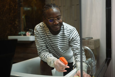 Young man using mobile phone while sitting on table