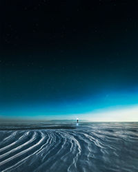 A man in scenic view of snowy landscape against sky at night