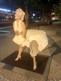 Full length of woman sitting on street at night