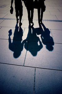 Low section of people standing on tiled floor