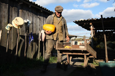 Man working on vehicle against sky