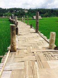 Wooden fence on field against sky