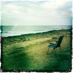 Chairs on beach against sky