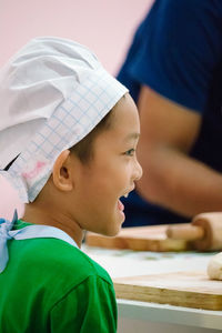 Close-up of happy child wearing chef hat in kitchen