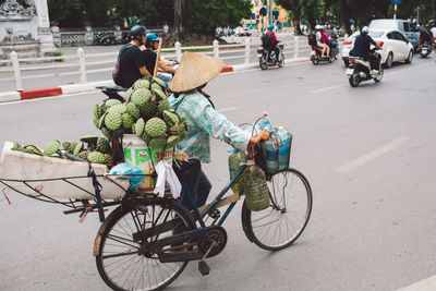 Market vendor carrying plant pods on bicycle in city