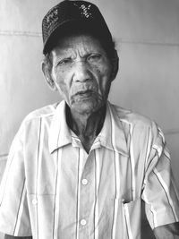 Portrait of man wearing hat against wall