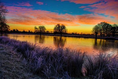 Scenic view of lake against sky at sunset