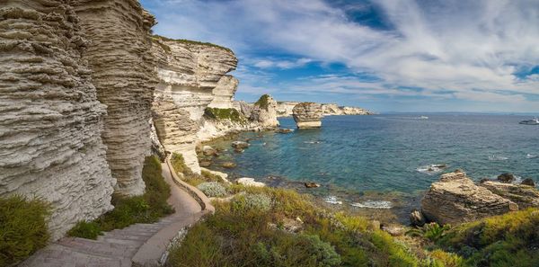 Scenic view of rock formation by sea against sky