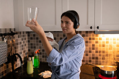 Young woman holding ice cream at home