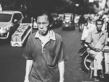 Portrait of man standing on street in city