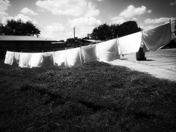 Clothes drying on clothesline on field against sky