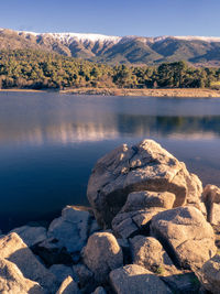 Scenic view of rocks by lake against sky