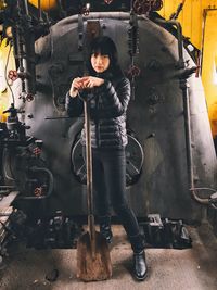 Portrait of woman standing while holding shovel in train