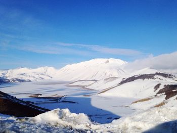 Scenic view of snow mountains against blue sky