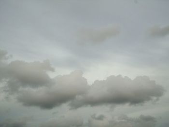 Low angle view of sunlight streaming through clouds