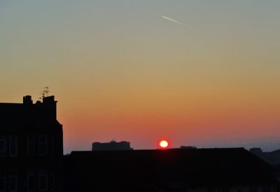 Buildings in city against sky during sunset