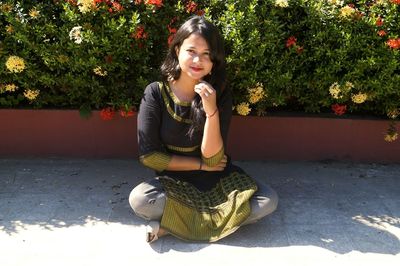 Portrait of young woman sitting outdoors