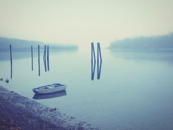 Rowboat moored in connecticut river against sky during foggy weather