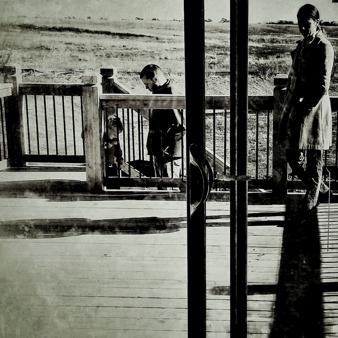 WOMAN LOOKING THROUGH WOODEN DOOR