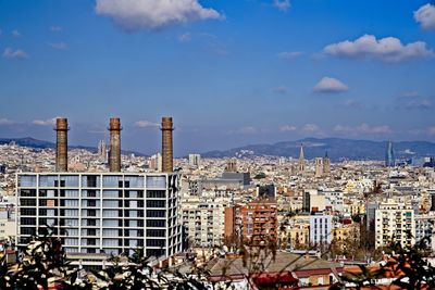 Aerial view of buildings in city against sky