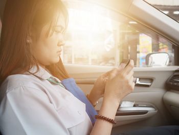 Woman using phone in car