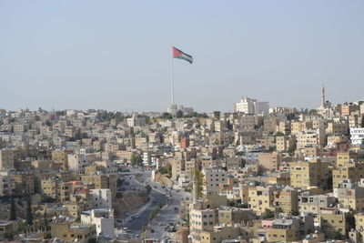 Aerial view of buildings in town against clear sky