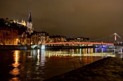 Bridge over river in city at night