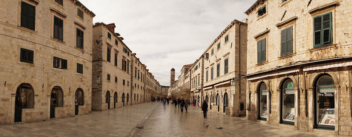 Street amidst buildings against sky in city