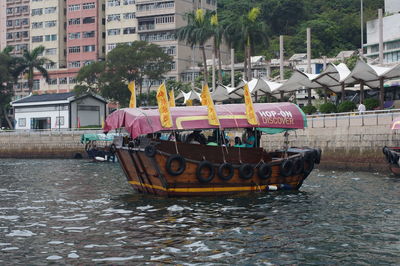 Boats moored on river against buildings in city