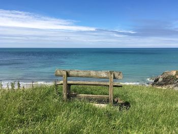 Scenic view of bench and sea against sky