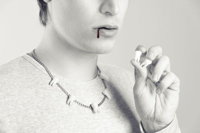 Close-up of woman holding hands over white background