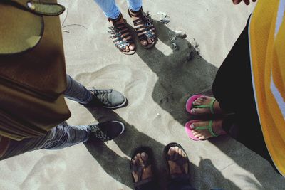 Low section of friends standing at beach