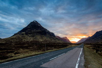 Empty road against sky during sunset