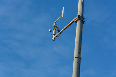 Low angle view of weather vane against sky