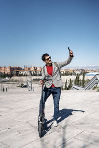 Man standing with umbrella against clear sky