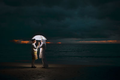 Full length of man standing at beach against sky