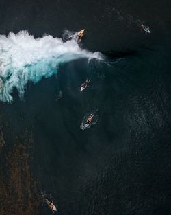 High angle view of people surfboarding in sea