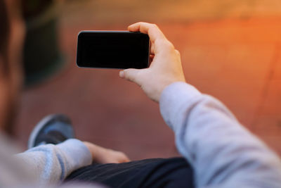Midsection of man photographing with mobile phone