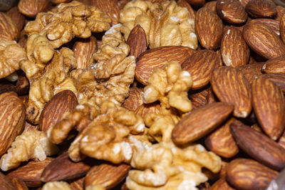 Peeled almond seeds and walnuts, close up background.