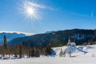 Scenic view of snowcapped mountains against blue sky on sunny day