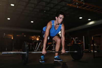 Man with artificial leg lifting dumbbell in gym