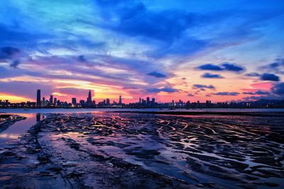 View of city at waterfront during sunset