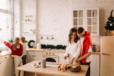 Family with children having fun and laughing while preparing for the christmas holiday in kitchen