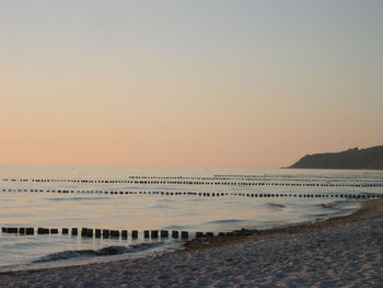 Scenic view of beach against clear sky during sunset