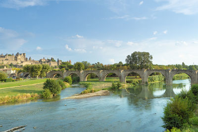 Arch bridge over river against sky