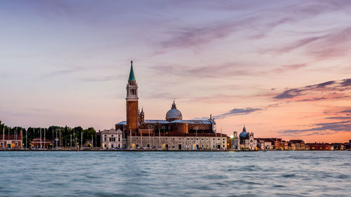 View of city at waterfront during sunset