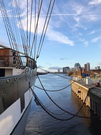 Sailboats moored in sea against sky in city