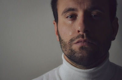 Close-up portrait of young man against gray background