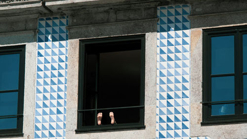 Open window of house with some feet showing
