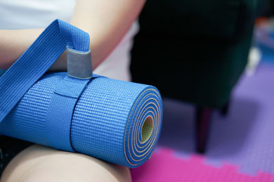 Close-up of person holding yoga mat 